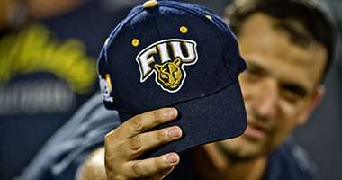Student holding FIU hat at football game 